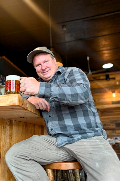 Man enjoying beer in rustic pub setting.
